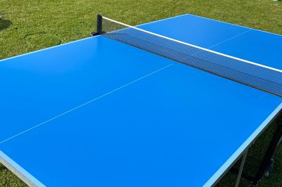 Trois valises vintage empilées, en cuir et tissu, posées sur une surface en extérieur avec de l'herbe en arrière-plan.