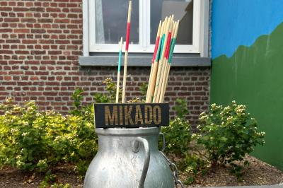 Trois valises vintage empilées, en cuir et tissu, posées sur une surface en extérieur avec de l'herbe en arrière-plan.