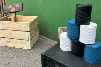 Trois valises vintage empilées, en cuir et tissu, posées sur une surface en extérieur avec de l'herbe en arrière-plan.