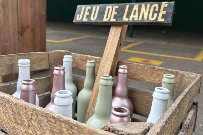 Trois valises vintage empilées, en cuir et tissu, posées sur une surface en extérieur avec de l'herbe en arrière-plan.