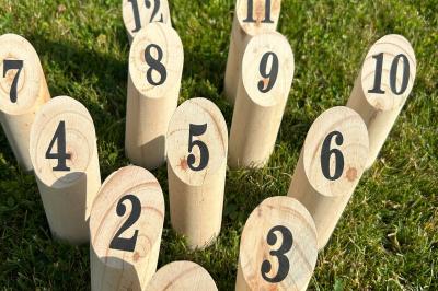 Trois valises vintage empilées, en cuir et tissu, posées sur une surface en extérieur avec de l'herbe en arrière-plan.