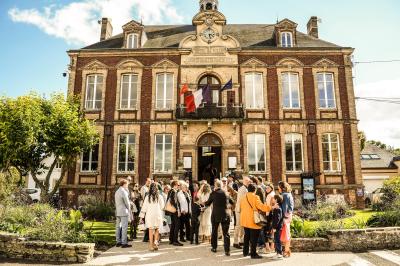 Un couple en tenue de mariage danse dans un jardin baigné par une lumière dorée.