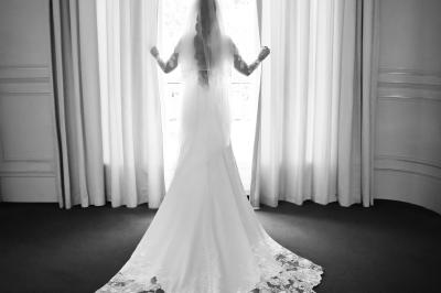 Un couple en tenue de mariage danse dans un jardin baigné par une lumière dorée.