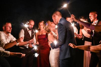 Un couple en tenue de mariage danse dans un jardin baigné par une lumière dorée.