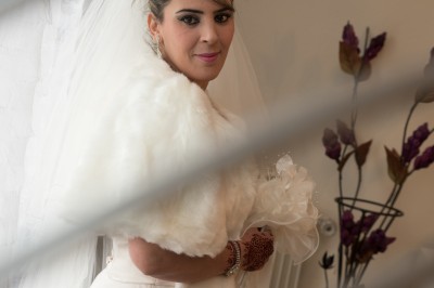 Voiture ancienne décapotable décorée de fleurs pour une cérémonie, stationnée sur une rue pavée.