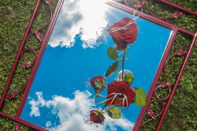Voiture ancienne décapotable décorée de fleurs pour une cérémonie, stationnée sur une rue pavée.
