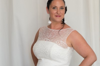 Voiture ancienne décapotable décorée de fleurs pour une cérémonie, stationnée sur une rue pavée.