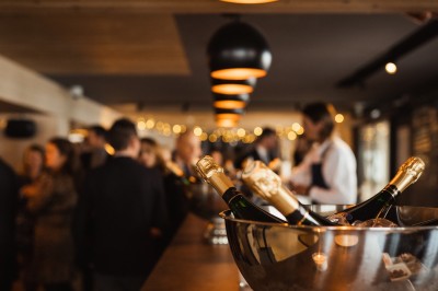 Miniature Location salle La Clusaz (Haute-Savoie) - Le 1647 #11 Un couple en tenue de mariage se tient dans un paysage montagneux au coucher du soleil, entouré de sapins.