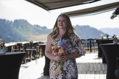 Miniature Location salle La Clusaz (Haute-Savoie) - Le 1647 #12 Un couple en tenue de mariage se tient dans un paysage montagneux au coucher du soleil, entouré de sapins.