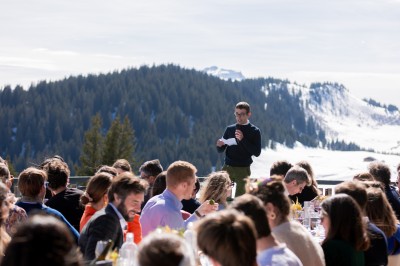 Miniature Location salle La Clusaz (Haute-Savoie) - Le 1647 #14 Un couple en tenue de mariage se tient dans un paysage montagneux au coucher du soleil, entouré de sapins.