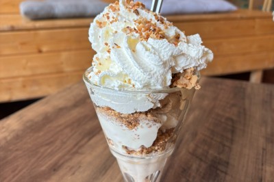 Assiette contenant une tranche de viande saignante, purée de pommes de terre et carottes glacées, nappée de sauce.