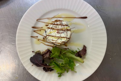 Assiette contenant une tranche de viande saignante, purée de pommes de terre et carottes glacées, nappée de sauce.