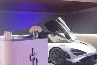 Trois stands promotionnels avec panneaux rouges et logos d'entreprises, disposés devant des banquettes dans un espace…