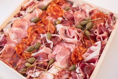 Tentacules de poulpe en train de cuire dans une poêle, manipulés avec une pince en métal.