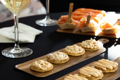 Tentacules de poulpe en train de cuire dans une poêle, manipulés avec une pince en métal.
