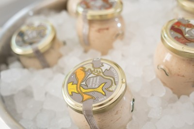 Tentacules de poulpe en train de cuire dans une poêle, manipulés avec une pince en métal.