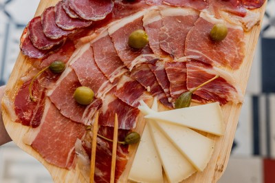 Tentacules de poulpe en train de cuire dans une poêle, manipulés avec une pince en métal.