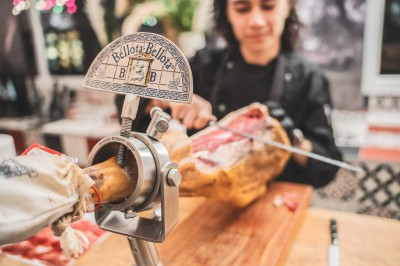 Tentacules de poulpe grillés dans une poêle chaude, manipulés avec une pince en cuisine.