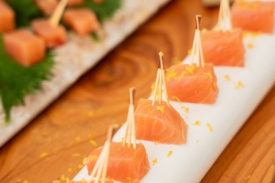 Tentacules de poulpe grillés dans une poêle chaude, manipulés avec une pince en cuisine.