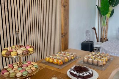 Château entouré de verdure avec ciel bleu, arbres et collines en arrière-plan.