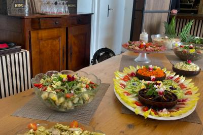Château entouré de verdure avec ciel bleu, arbres et collines en arrière-plan.