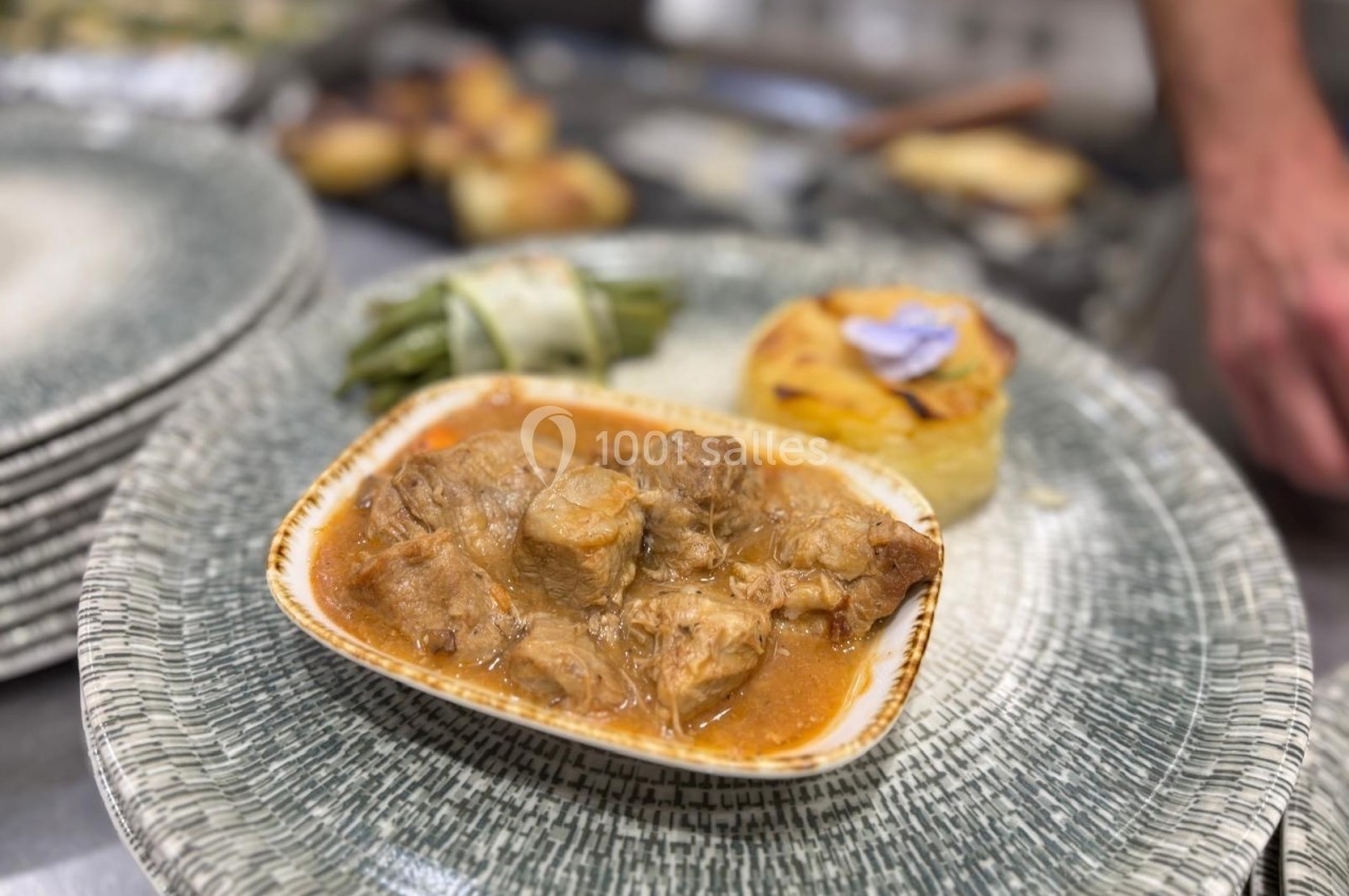 Assiette contenant un plat de viande en sauce, accompagné de haricots verts liés et d'un gratin individuel.