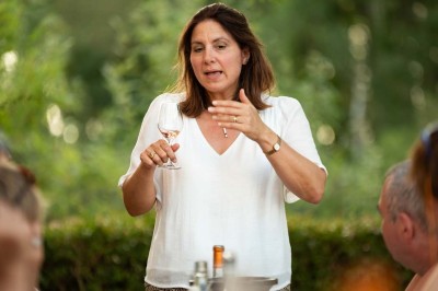 Chambre avec lit double, poutres apparentes, éclairage doux, murs décorés et mobilier blanc.