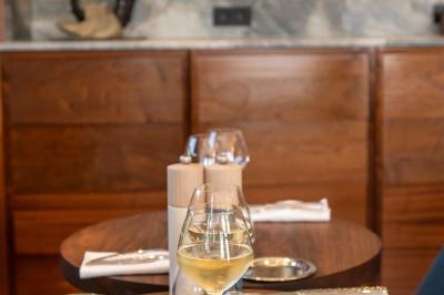 Table rouge avec assiettes, pain, olives, tomates, houmous, boisson orange et lampe, en extérieur.