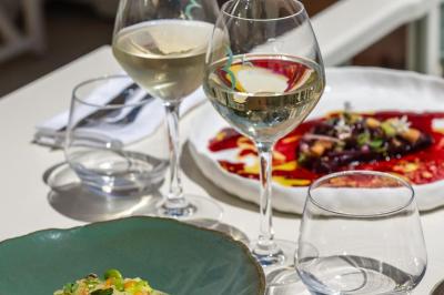 Table rouge avec assiettes, pain, olives, tomates, houmous, boisson orange et lampe, en extérieur.