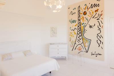 Vue d'une maison en pierre avec piscine, entourée de végétation, donnant sur une vallée et des collines sous un ciel bleu.