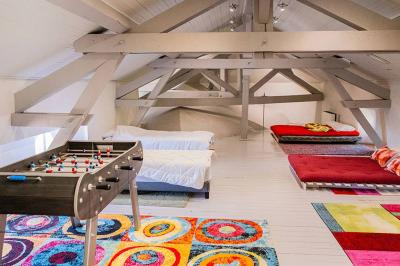 Vue d'une maison en pierre avec piscine, entourée de végétation, donnant sur une vallée et des collines sous un ciel bleu.