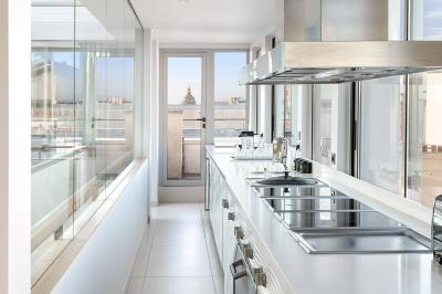 Salon lumineux avec canapé beige, table basse en bois, salle à manger attenante et escalier en arrière-plan.