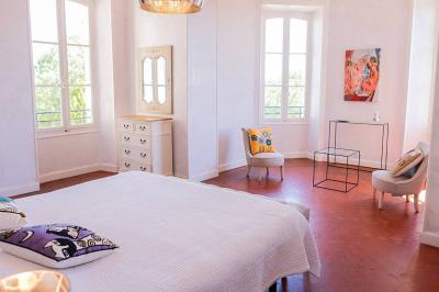 Salon lumineux avec canapé beige, table basse en bois, salle à manger attenante et escalier en arrière-plan.
