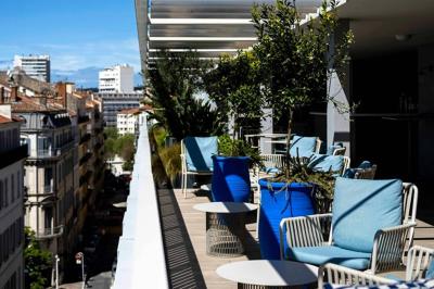 Espace lounge moderne avec fauteuils design, colonnes décorées de dégradés bleus et mobilier aux tons neutres.