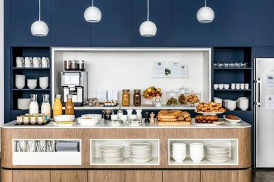 Espace lounge moderne avec fauteuils design, colonnes décorées de dégradés bleus et mobilier aux tons neutres.