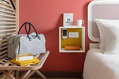 Espace lounge moderne avec fauteuils design, colonnes décorées de dégradés bleus et mobilier aux tons neutres.