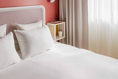 Espace lounge moderne avec fauteuils design, colonnes décorées de dégradés bleus et mobilier aux tons neutres.