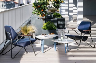 Espace lounge moderne avec fauteuils design, colonnes décorées de dégradés bleus et mobilier aux tons neutres.