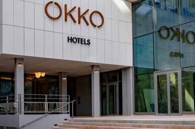 Espace lounge moderne avec fauteuils design, colonnes décorées de dégradés bleus et mobilier aux tons neutres.