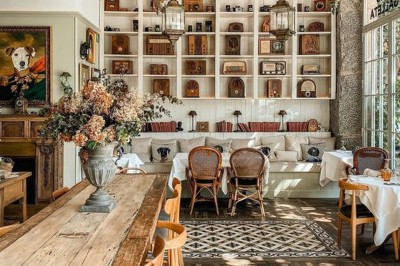 Salle de réunion lumineuse avec table en bois, chaises rembourrées, bouteilles d'eau et grandes fenêtres avec rideaux…