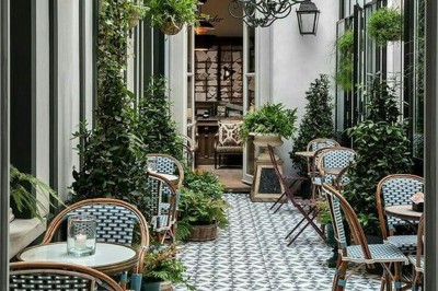 Salle de réunion lumineuse avec table en bois, chaises rembourrées, bouteilles d'eau et grandes fenêtres avec rideaux…