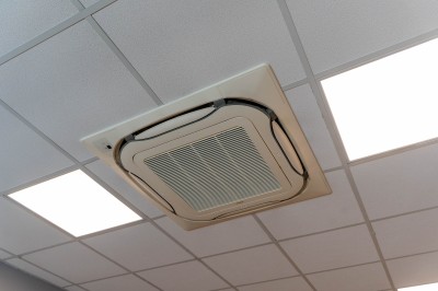 Façade d'un bâtiment commercial à deux étages avec parking et véhicules stationnés à l'avant.