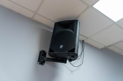 Façade d'un bâtiment commercial à deux étages avec parking et véhicules stationnés à l'avant.