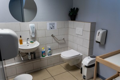 Façade d'un bâtiment commercial à deux étages avec parking et véhicules stationnés à l'avant.