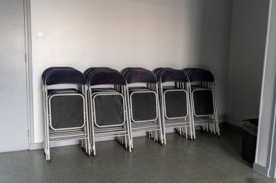 Façade d'un bâtiment commercial à deux étages avec parking et véhicules stationnés à l'avant.