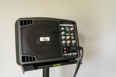 Façade d'un bâtiment commercial à deux étages avec parking et véhicules stationnés à l'avant.