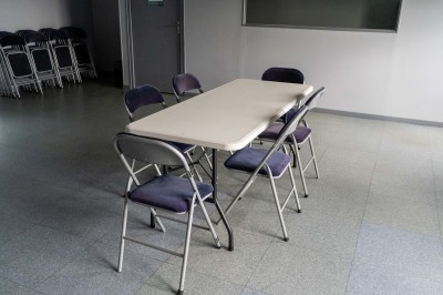 Façade d'un bâtiment commercial à deux étages avec parking et véhicules stationnés à l'avant.