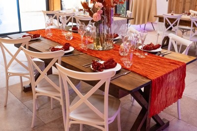 Salle de réception élégante avec tables rondes dressées, nappes blanches et décorations florales dans un cadre lumineux en…