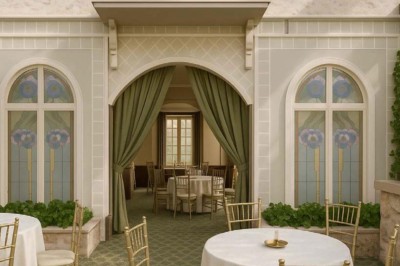 Statue moderne près d'un escalier en marbre et d'un ascenseur à portes vitrées dans un hall lumineux.