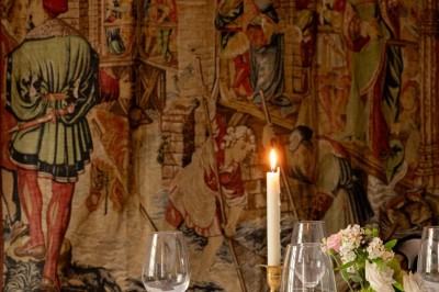 Salle de restaurant élégante avec tables dressées, chaises noires et décoration murale en treillis beige.
